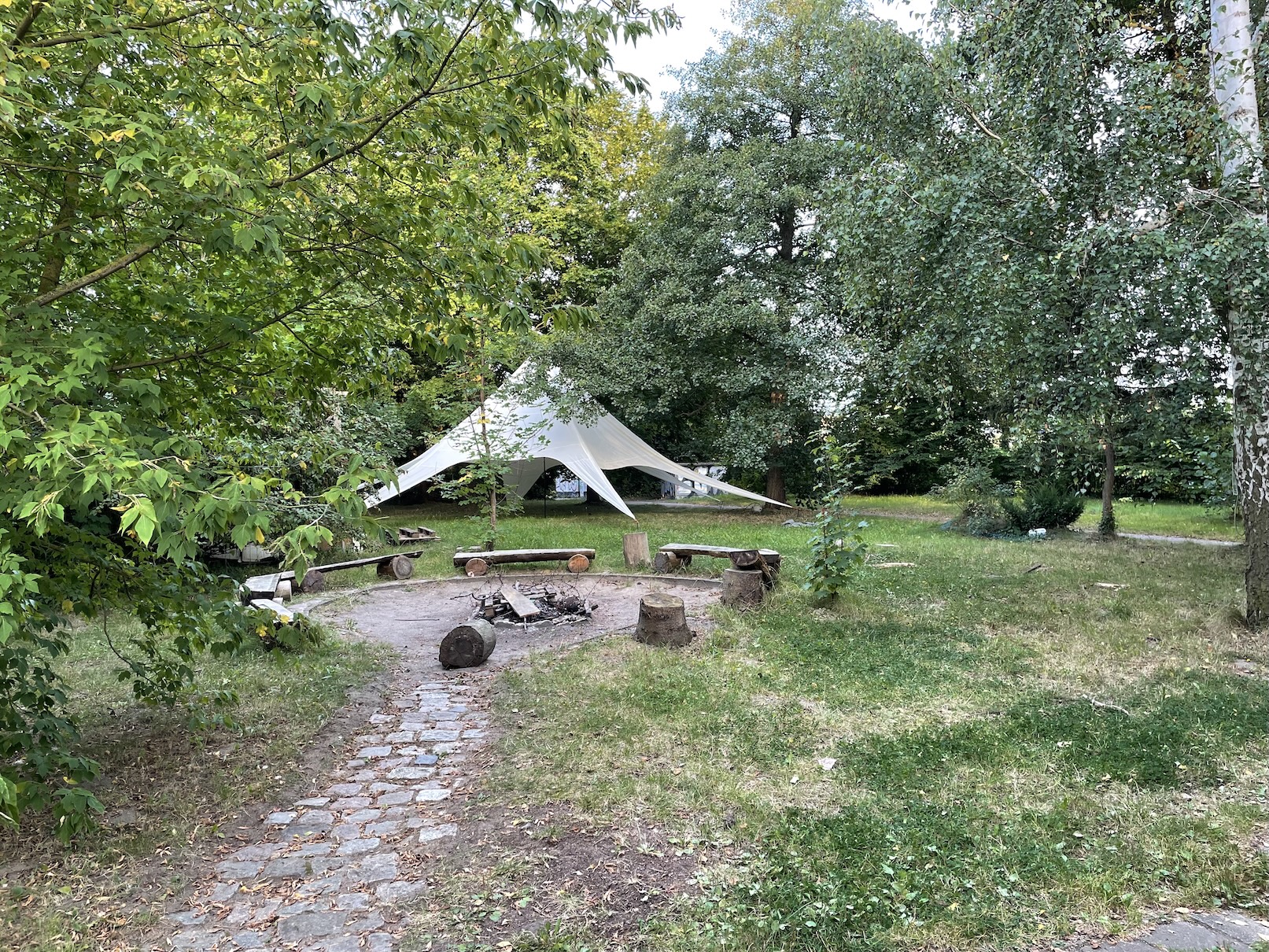 Wiese mit Feuerstelle und Zelt