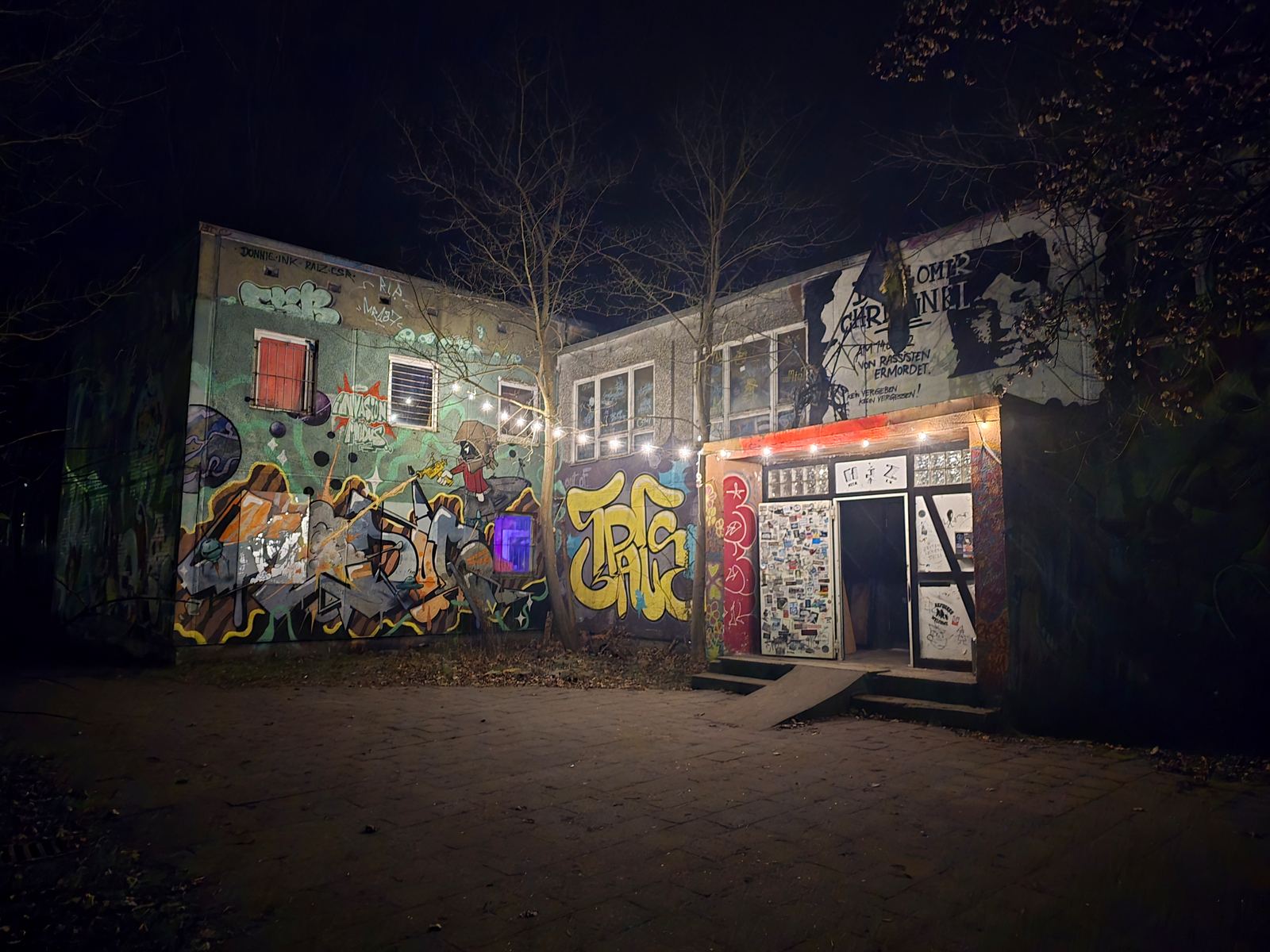 Der beleuchtete Eingang des AJZ bei Nacht